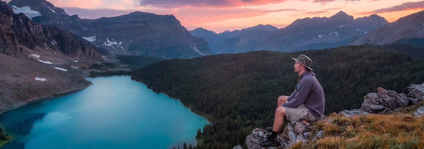 mountain outdoor sky valley nature canyon man lake person water landscape cloud tree highland crater land